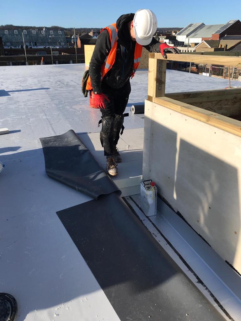Contractor installing Powerdeck F within single ply membrane waterproofing system