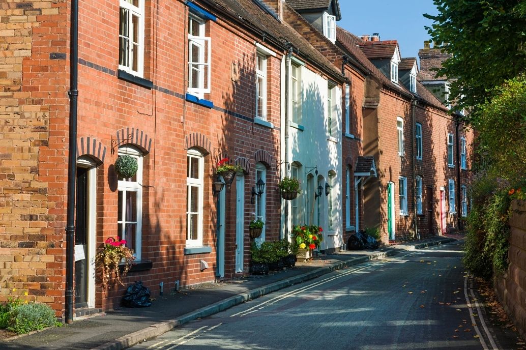UK housing street with trees and green space opposite promoting low carbon homes
