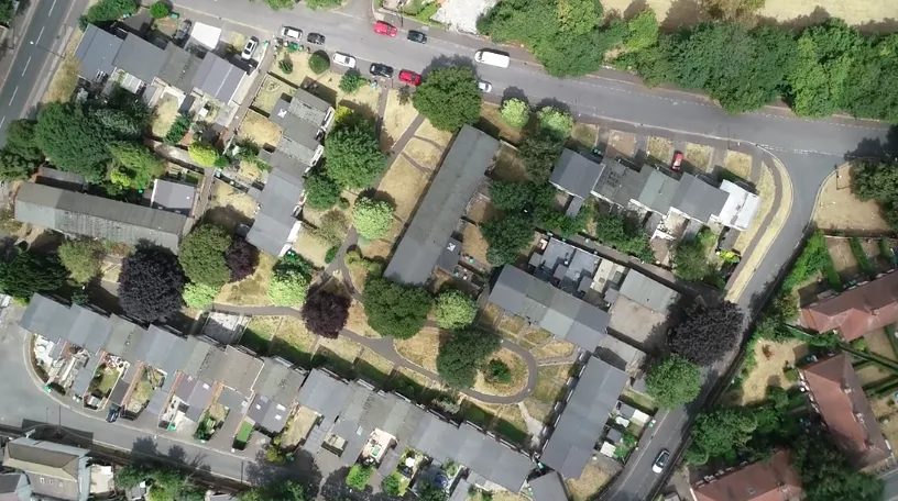 Aerial view of a residential area with houses and greenery.