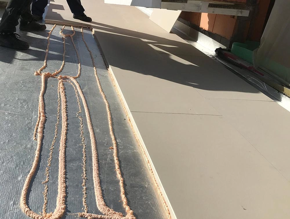 Recticel Insulation's Deck-VQ VIP insulation panel laid on a flat roof application close up image with glue